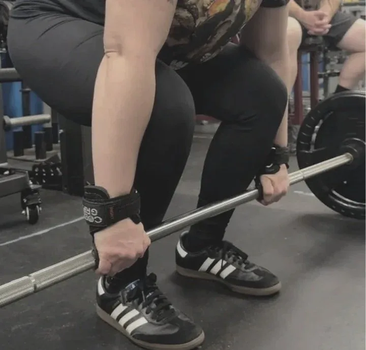Client gripping a barbell during a deadlift