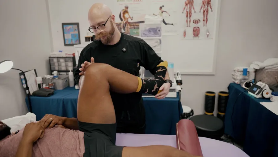 Practitioner rotating a client's knee during a session